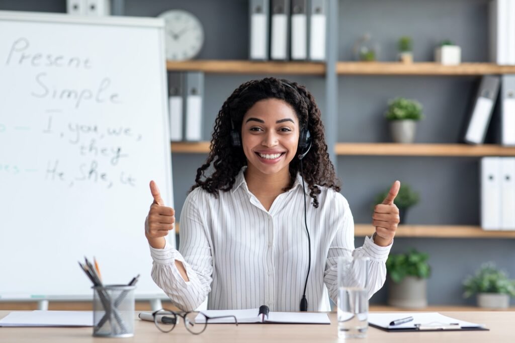 mujer de tono de piel oscura sonriendo y sacando los pulgares en gesto "bien echo"